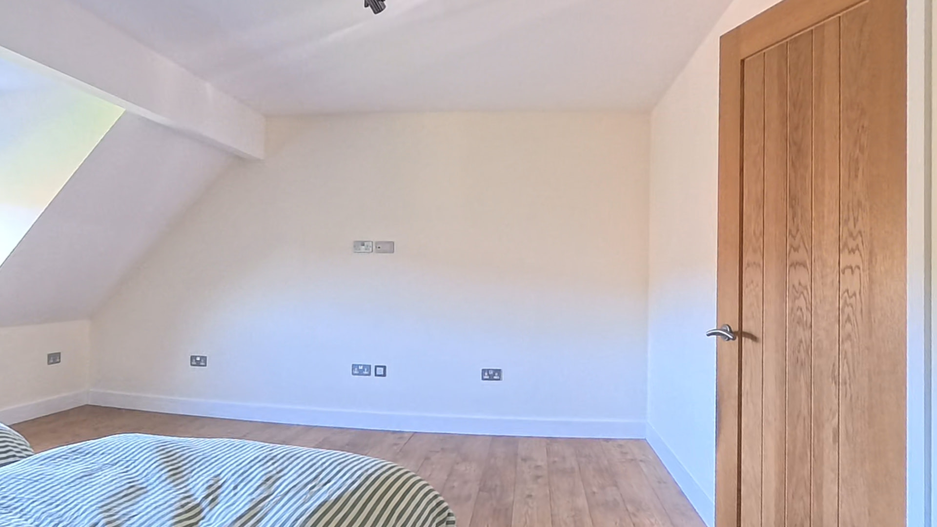 Empty sloping bedroom wall in Cardiff before light panel and mirror sliding wardrobe doors were fitted