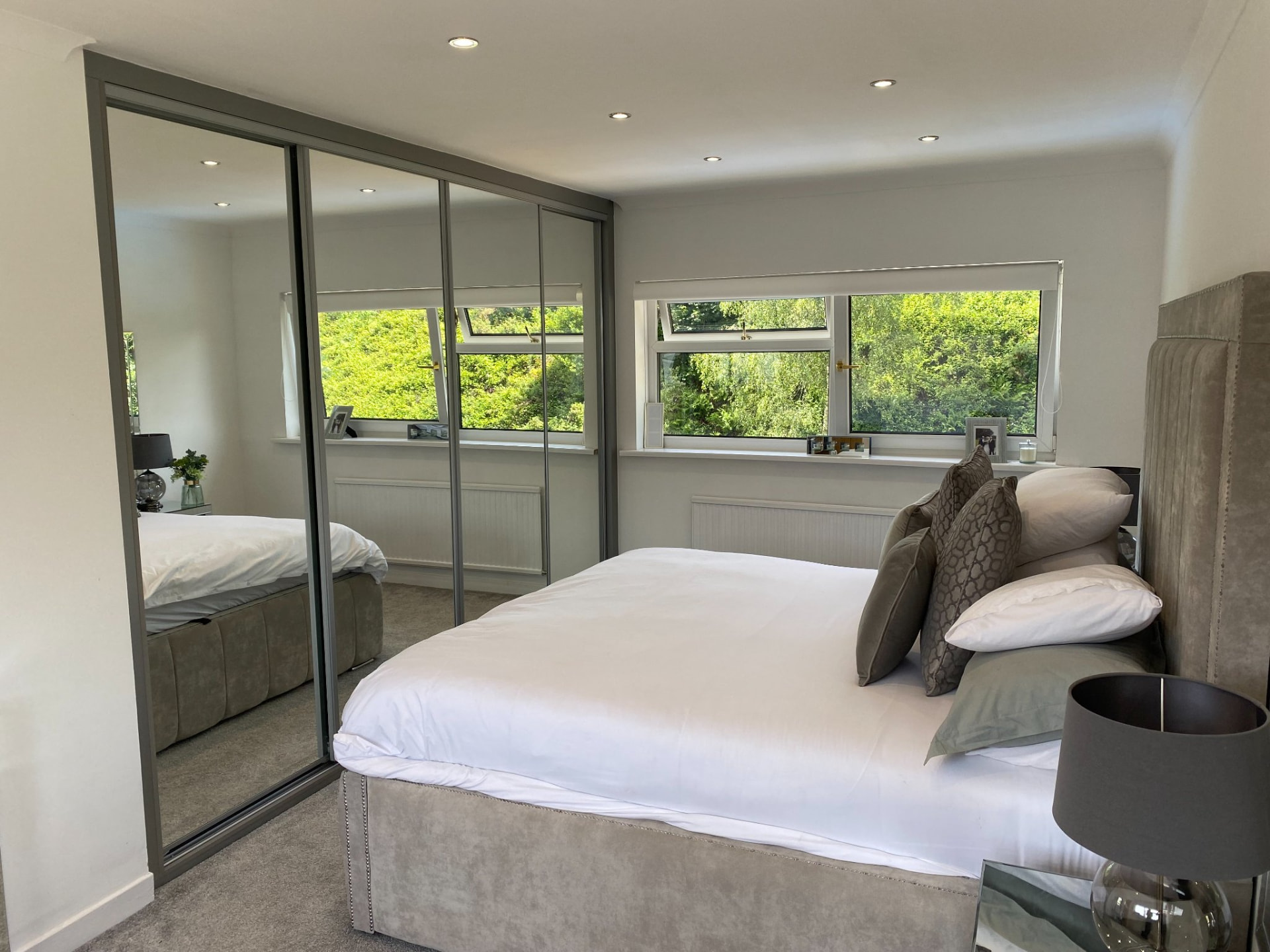 Graphite-framed tinted mirror sliding wardrobe doors in a Penarth bedroom